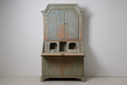 Genuine antique secretary cabinet from Sweden made in gustavian style. The piece is a secretary desk with an upper cabinet, made by hand in solid pine around 1820 in northern Sweden