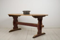 Antique Swedish dining table in folk art from the early 1800s. The table is a so called trestle table with a heavy table top on a sturdy leg frame.