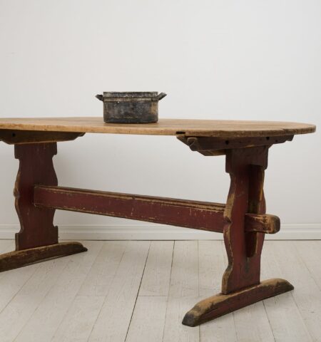 Antique Swedish dining table in folk art from the early 1800s. The table is a so called trestle table with a heavy table top on a sturdy leg frame.