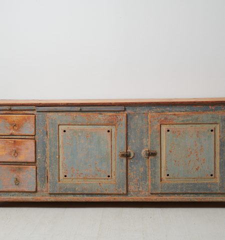 Low and wide genuine sideboard from the mid 1800s. The sideboard is a genuine Swedish country house furniture made in painted pine