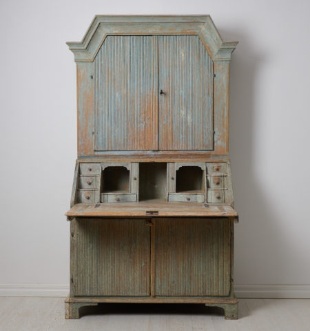 Genuine antique secretary cabinet from Sweden made in gustavian style. The piece is a secretary desk with an upper cabinet, made by hand in solid pine around 1820 in northern Sweden