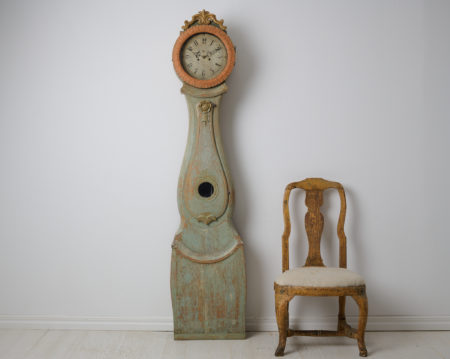 Country long case clock in rococo style from northern Sweden. This clock is a genuine antique from around the 1820s. The carved wooden decor is original