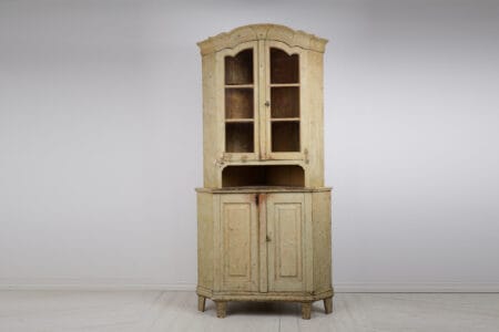 Gustavian period corner cabinet with glass doors from Sweden made during the 1790s. The cabinet is made by hand in solid pine into two parts