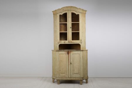 Gustavian period corner cabinet with glass doors from Sweden made during the 1790s. The cabinet is made by hand in solid pine into two parts