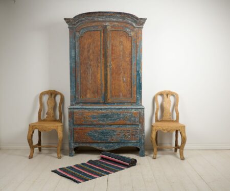 Genuine folk art cabinet in rococo from northern Sweden, made around 1780. This antique cabinet is made in solid pine and can be separated into two parts